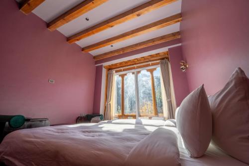 a bedroom with a large bed with a large window at Taktsangri-La in Drugyel Dzong