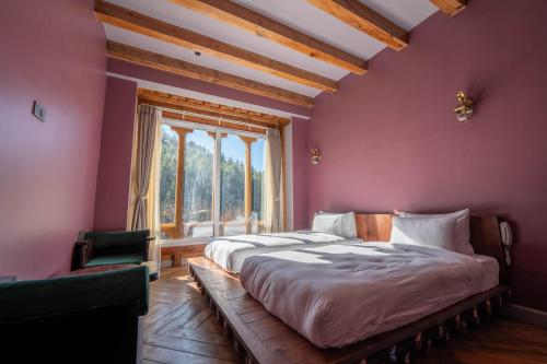 a bedroom with a large bed and a window at Taktsangri-La in Drugyel Dzong
