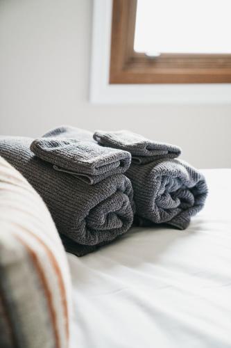 a pile of towels sitting on top of a bed at Highgrove Cottage in Eurunderee