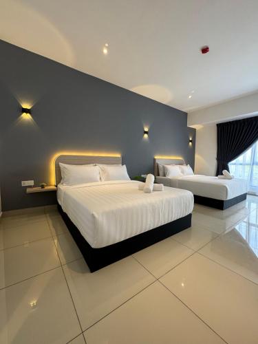 a bedroom with two beds and a blue wall at Maca Hotel by Sky Hive in George Town