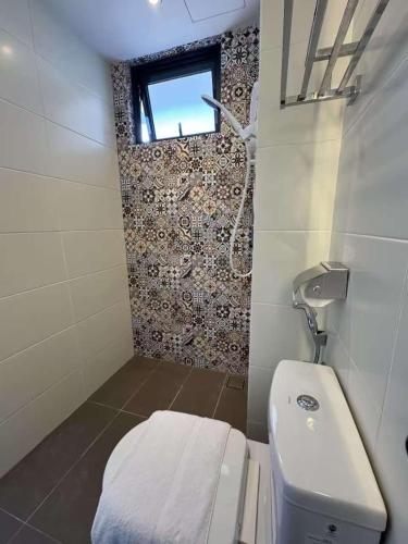 a small bathroom with a toilet and a window at Maca Hotel by Sky Hive in George Town