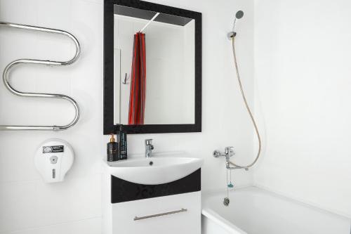 a bathroom with a sink and a mirror at Люкс Крупская 78 in Pavlodar