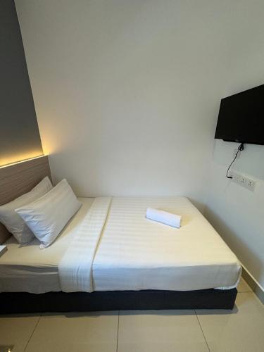 a small bedroom with a bed with a towel on it at Maca Hotel by Sky Hive in George Town