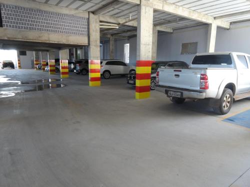 a white truck parked in a parking lot with columns at Di Napoli Plaza Hotel in Gurupi