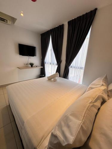 a bedroom with a large white bed and two windows at Maca Hotel by Sky Hive in George Town