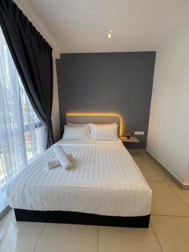 a bedroom with a white bed with a large window at Maca Hotel by Sky Hive in George Town