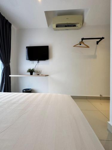a room with a bed and a tv on a wall at Maca Hotel by Sky Hive in George Town