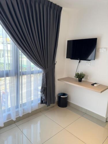 a room with a curtain and a tv and a window at Maca Hotel by Sky Hive in George Town