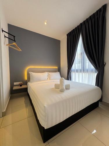 a bedroom with a large white bed with a window at Maca Hotel by Sky Hive in George Town