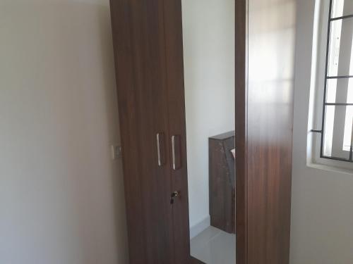 a wooden door in a room with a television at SathyaBama Mohan Illam in Chennai