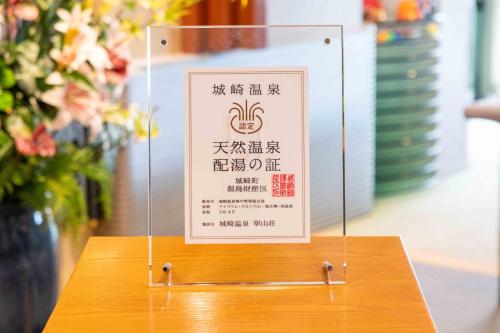 a sign sitting on top of a wooden table at Suizansou in Toyooka