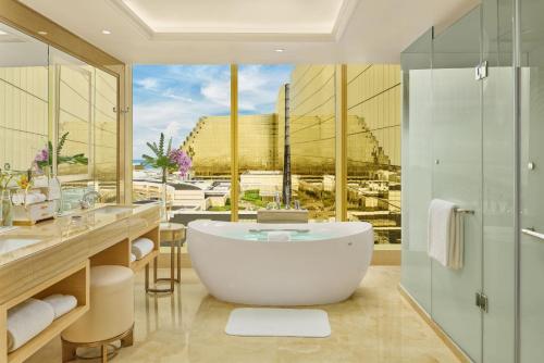 a bathroom with a tub and a large window at Okada Manila in Manila