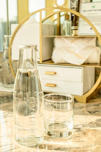 a glass bottle and a glass of water on a table at Okada Manila in Manila