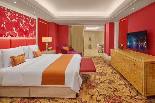 a bedroom with a large bed and a red wall at Okada Manila in Manila