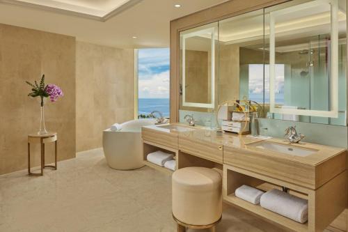 a bathroom with a tub and a large mirror at Okada Manila in Manila