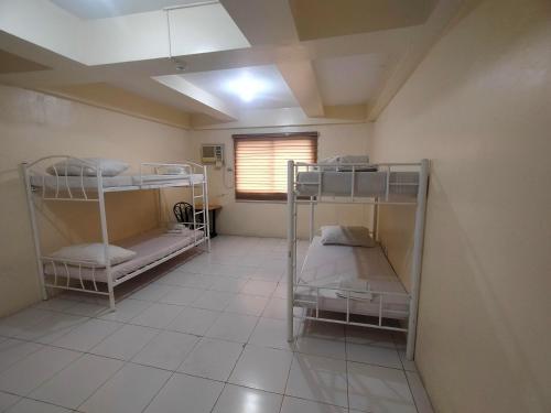 a room with three bunk beds and a window at DDD Habitat, Inc - Bacolod in Bacolod