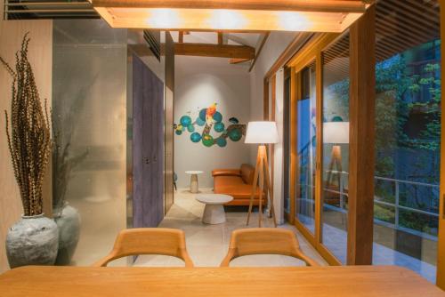 a dining room with a table and chairs and a couch at 湯の里いけもり別館 天座 in Himi