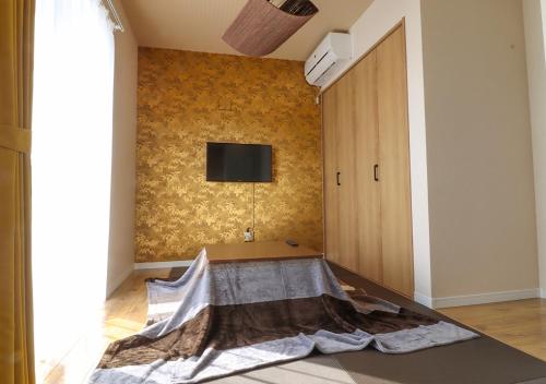 a living room with a tv on a wall at ル グランブリュリゾート長沢 l テラスでゆったりオーシャンビュージャグジー 1棟貸切 小型犬可 無料駐車場付 in Kōembō