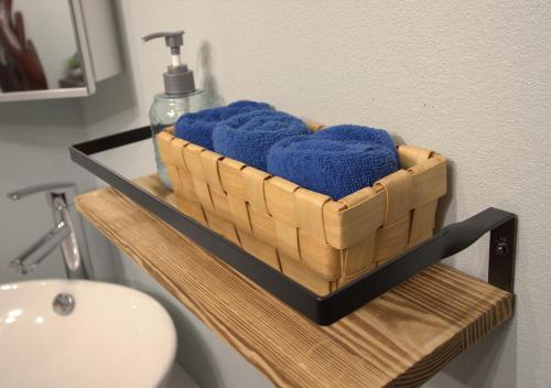 a basket of blue towels on a shelf in a bathroom at ル グランブリュリゾート長沢 l テラスでゆったりオーシャンビュージャグジー 1棟貸切 小型犬可 無料駐車場付 in Kōembō