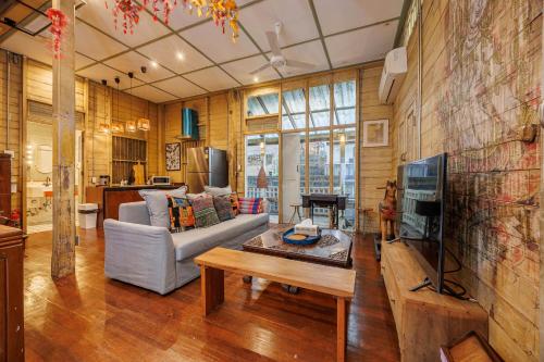 ein Wohnzimmer mit Sofa und Fernseher in der Unterkunft The Anonymous House in Bangkok