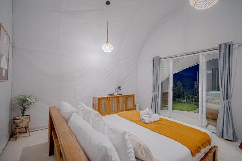 a bedroom with a large bed and a window at Onion Hill Glamping Managed by Manara in Kintamani