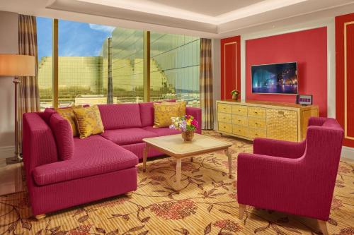a living room with a purple couch and two chairs at Okada Manila in Manila