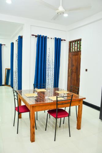 a dining room with a wooden table and chairs at Ocean Bliss Villa Mirissa in Kamburugamuwa