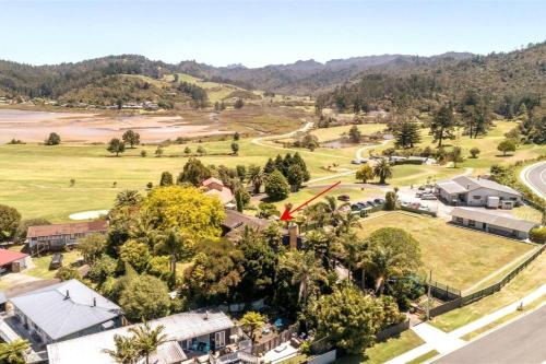 an aerial view of a village with trees and a road at Surf and Stay in Tairua