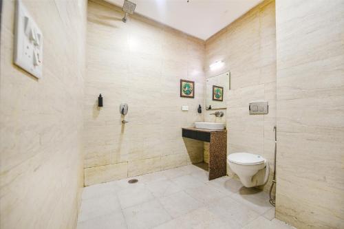 a bathroom with a toilet and a sink at FabExpress Shri Sai DX - Nr Adarsh Nagar Metro in New Delhi