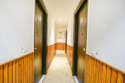 a hallway with wood paneling and doors in a building at FabExpress Shri Sai DX - Nr Adarsh Nagar Metro in New Delhi