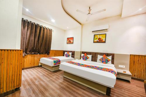 a bedroom with two beds and a window at FabExpress Shri Sai DX - Nr Adarsh Nagar Metro in New Delhi