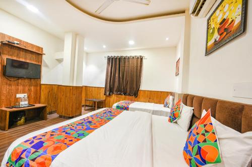 a bedroom with two beds and a tv at FabExpress Shri Sai DX - Nr Adarsh Nagar Metro in New Delhi