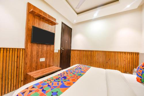 a bedroom with a bed and a flat screen tv at FabExpress Shri Sai DX - Nr Adarsh Nagar Metro in New Delhi