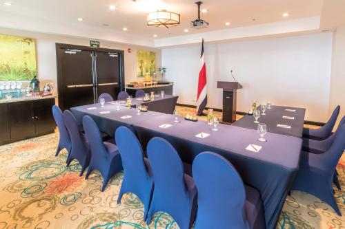 a conference room with a long table and blue chairs at Residence Inn by Marriott San Jose Escazu in San José