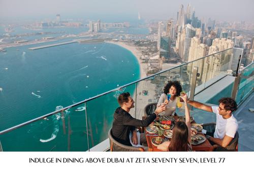 a group of people sitting at a table on an observation deck at Address Beach Resort in Dubai