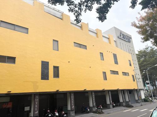 a yellow building with motorcycles parked in front of it at Xiadu Motel in Taichung