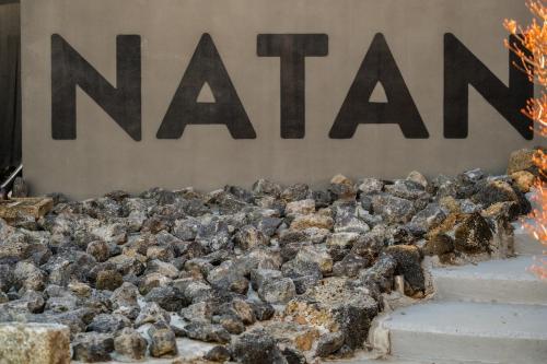 a pile of rocks in front of a nissan sign at NATAN - 7mins walk from Kawaguchiko Station in Fujikawaguchiko