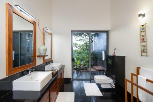 a bathroom with two sinks and a toilet at Heavensa Luxury Villas and Suites by The Clarks in Galle