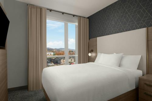 a bedroom with a white bed and a large window at Residence Inn by Marriott Eagle Boise in Eagle