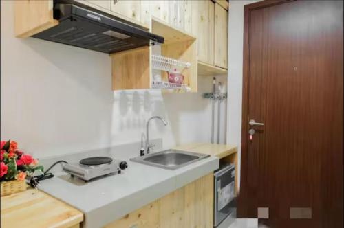 a kitchen with a sink and a counter top at Comfy Cozy Studio in BSD in Babakan