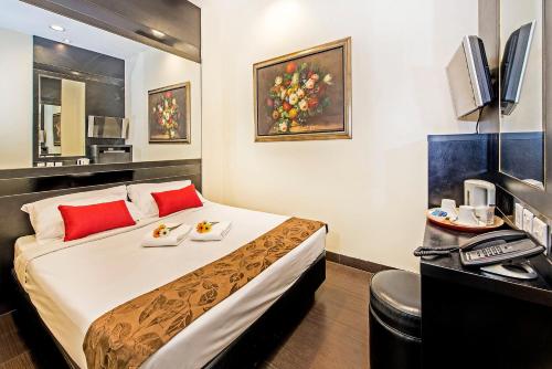 Pokój hotelowy z dużym łóżkiem z czerwonymi poduszkami w obiekcie Hotel 81 Kovan w Singapurze