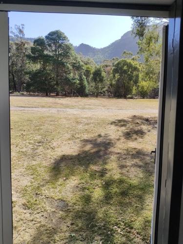 a view from a window of a field with trees at The Grampians Motel in Halls Gap