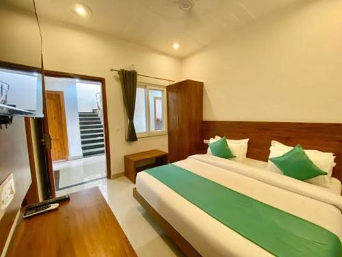 a bedroom with a bed and a flat screen tv at Triple One Hotel Tapovan Rishikesh,Near Laxman Jhula in Rishīkesh