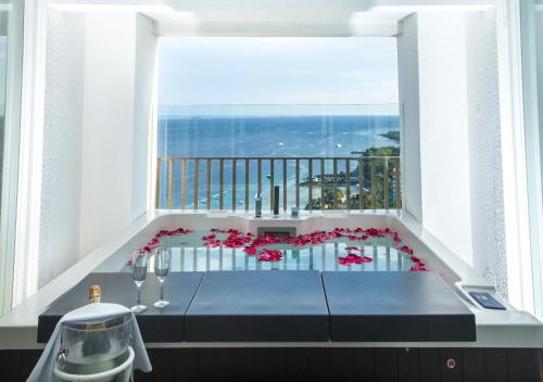 a room with a balcony with a table with flowers at Mövenpick Hotel Mactan Island Cebu in Mactan
