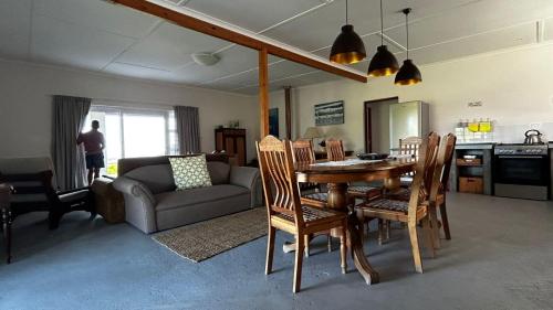 a living room with a table and chairs and a couch at Blombos Self-Catering House in Franskraal
