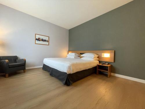 a hotel room with a bed and a chair at Crowne Plaza Milan Linate by IHG in San Donato Milanese