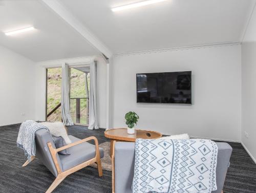 a living room with two chairs and a table at THE SHED - Tallebudgera Valley in Tallebudgera