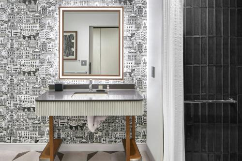a bathroom with a sink and a mirror at Hotel Celare, Cincinnati Midtown, a Tribute Portfolio Hotel in Cincinnati
