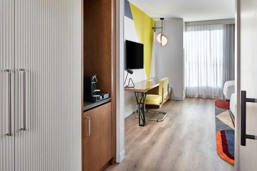 a room with a desk and a table with a television at Hotel Celare, Cincinnati Midtown, a Tribute Portfolio Hotel in Cincinnati