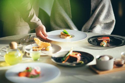 a person sitting at a table with plates of food at Kakegawa Grand Hotel in Kakegawa